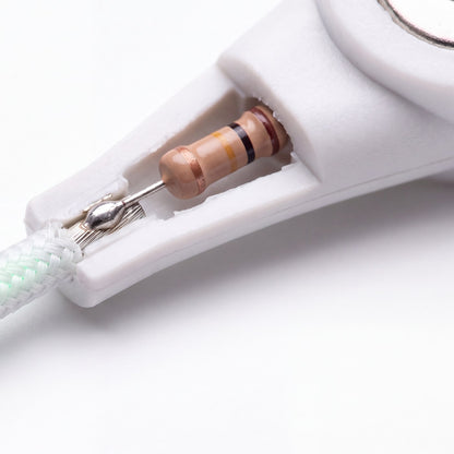 Cutaway illustration of the Naturalive grounding cord's snap end, showing the built-in 100 kΩ safety resistor